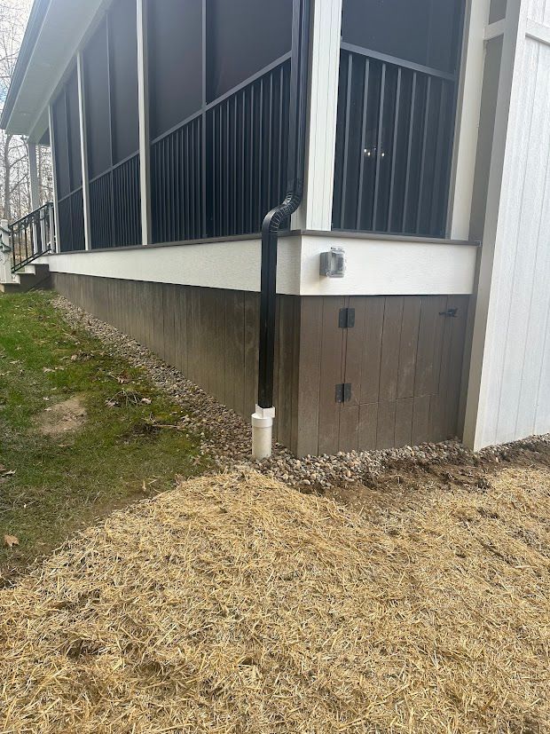 A house with a screened in porch and a black railing.