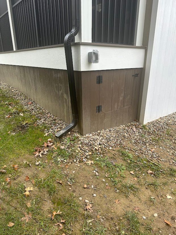 There is a drain pipe on the side of a house.