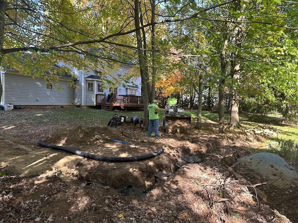 A man is standing in a pile of dirt in front of a house.