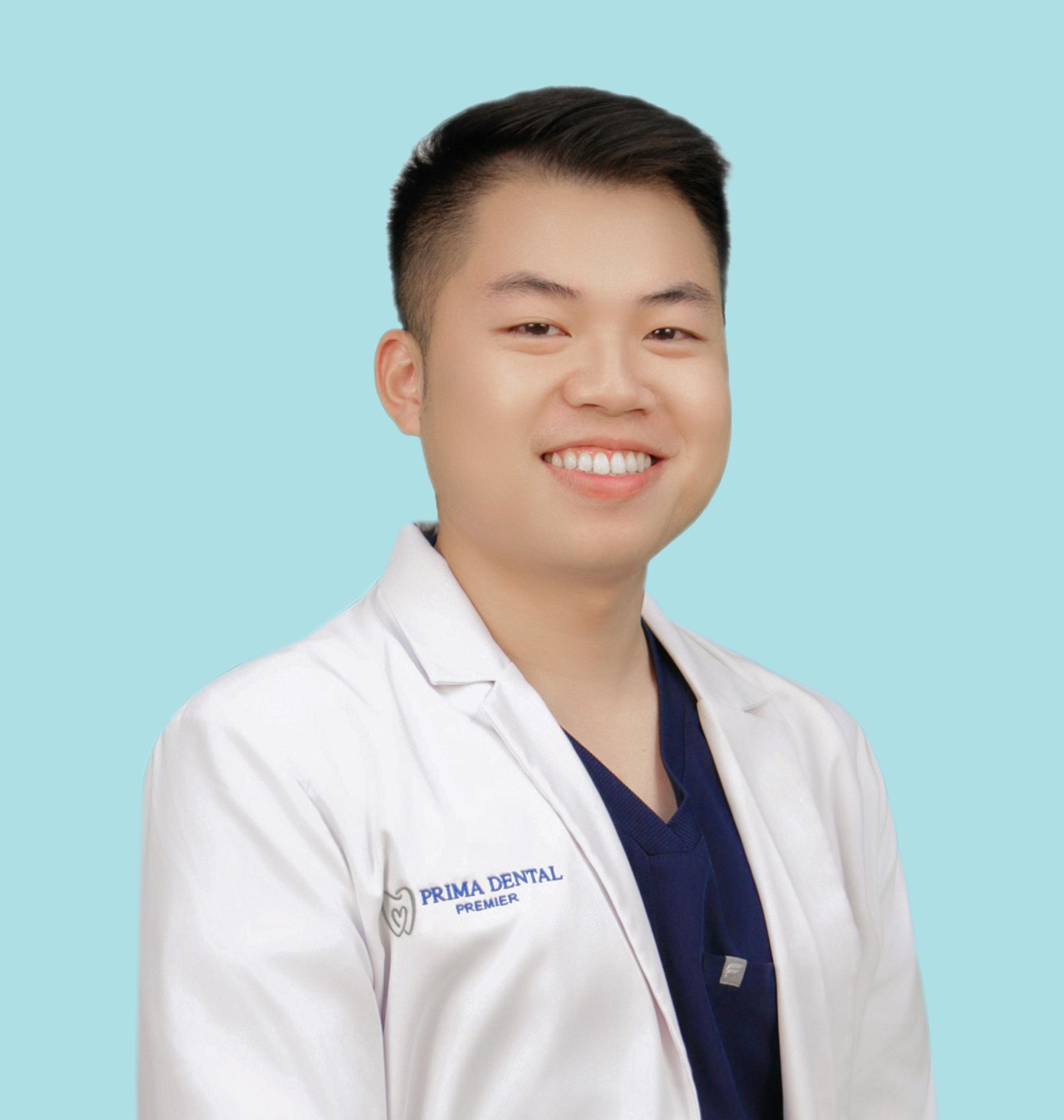 Smiling Dr. Ethan Nguyen in a white lab coat, blue scrubs, and a light blue background.
