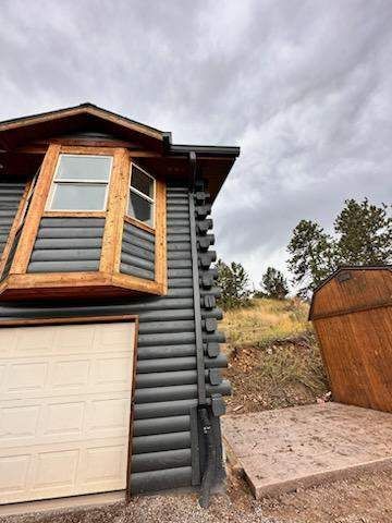 A log cabin with a garage door and a window.