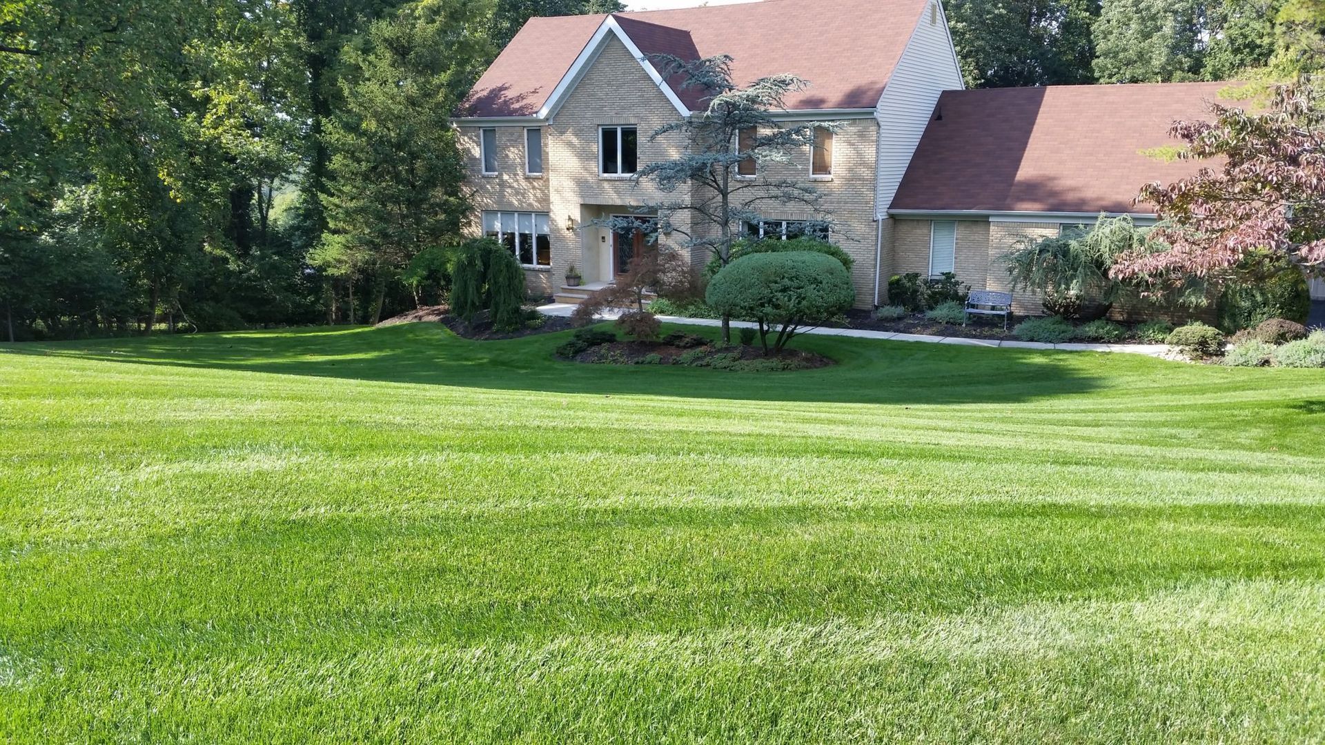 A large house with a lush green lawn in front of it.