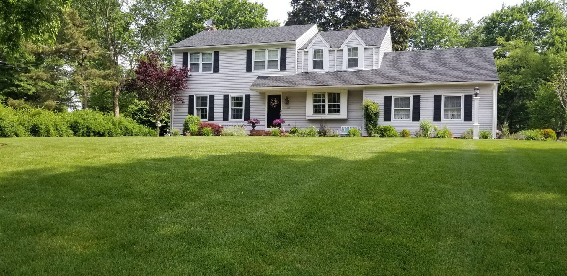A large white house with a lush green lawn in front of it.