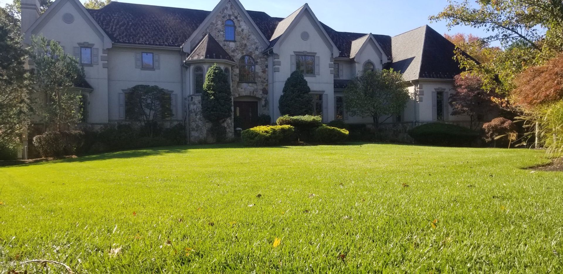 A large house with a lush green lawn in front of it.