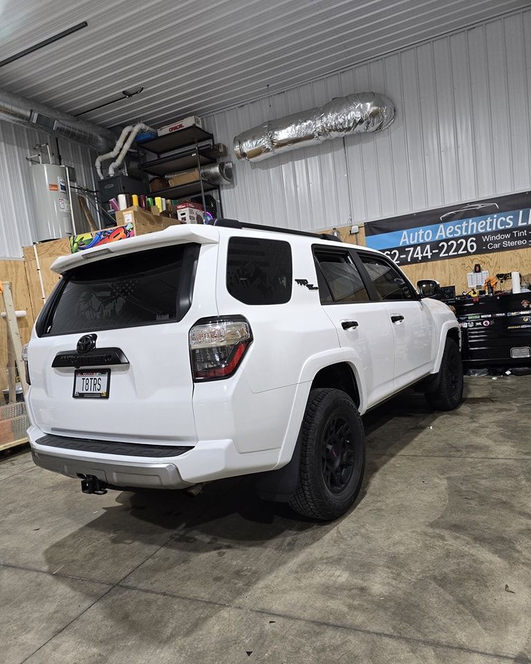 A white 4runner is parked in a garage.