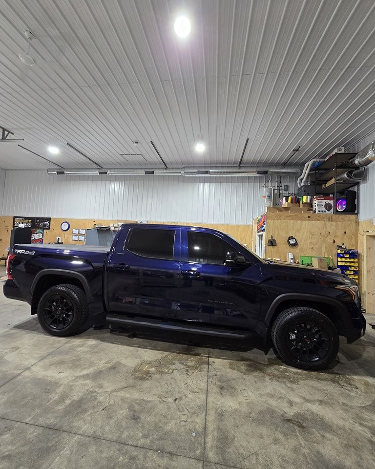 A blue truck is parked in a garage.