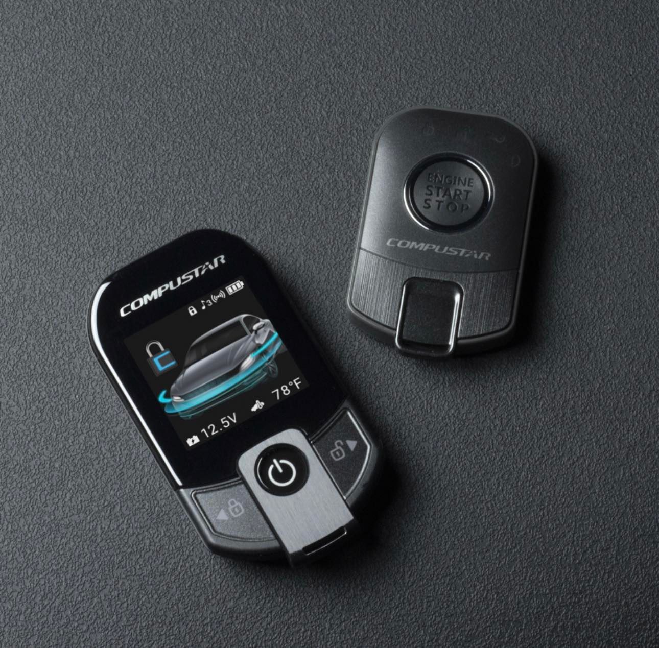 A compustar remote control sits next to another remote control