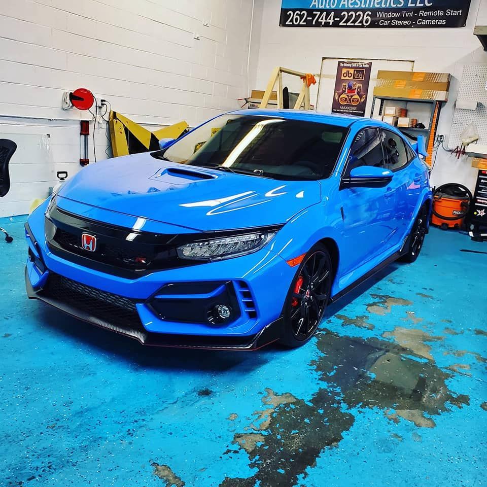 A blue honda civic type r is parked in a garage