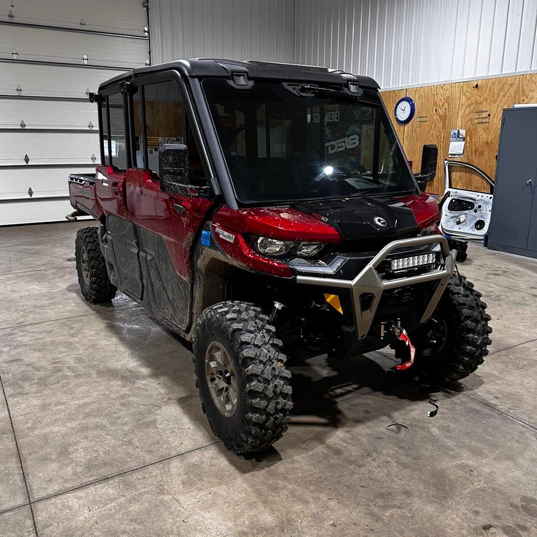 A red and black atv is parked in a garage.