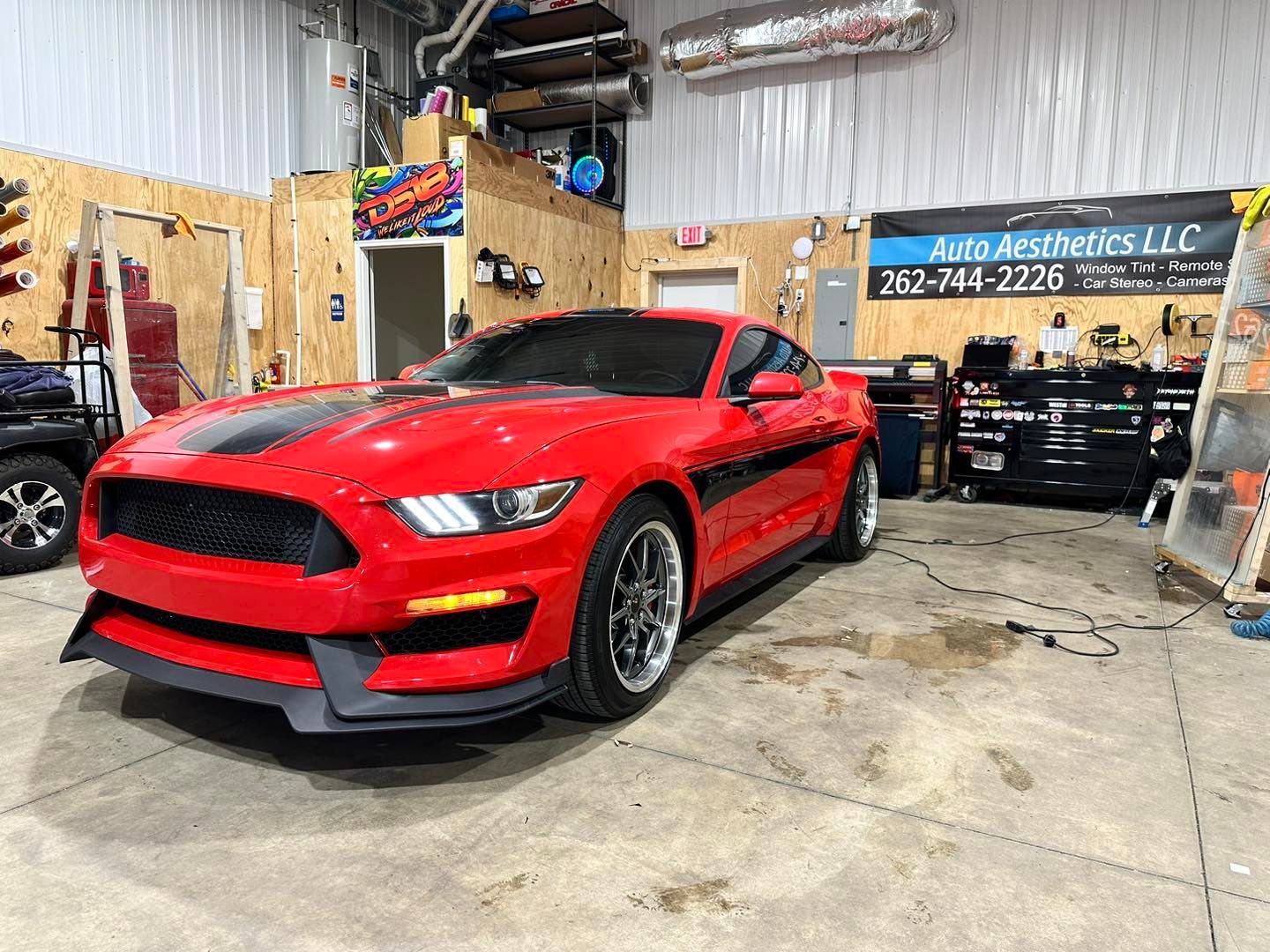 A red mustang is parked in a garage.