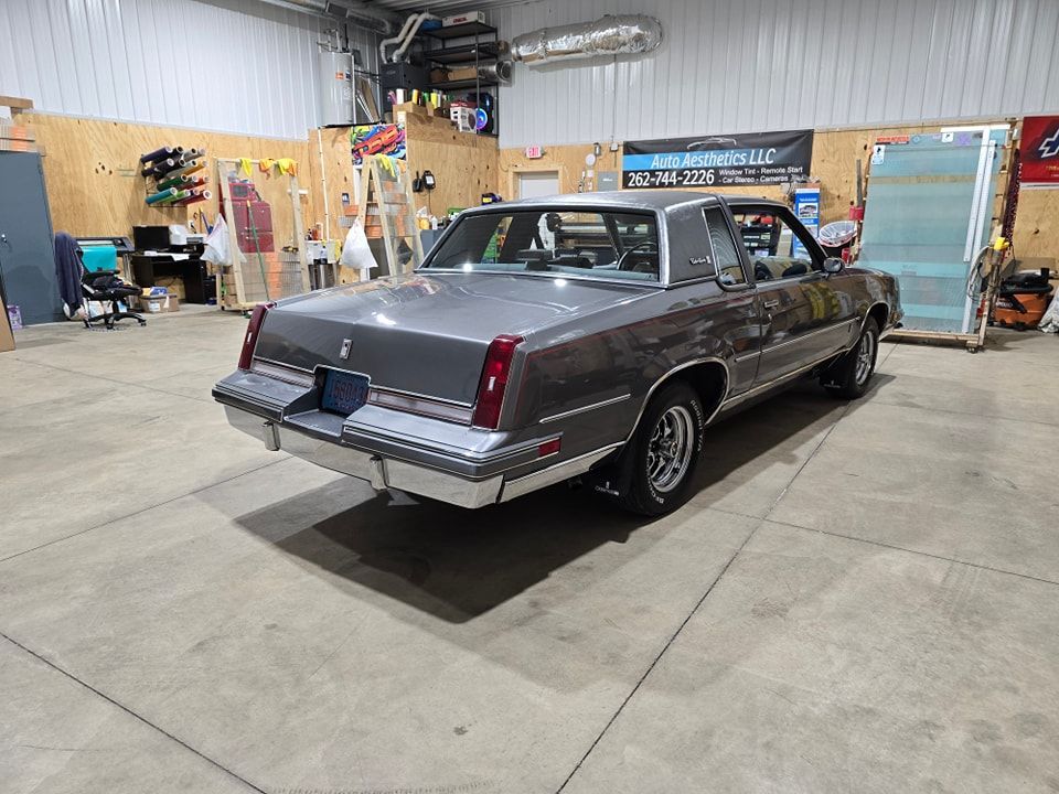 A gray car is parked in a garage.