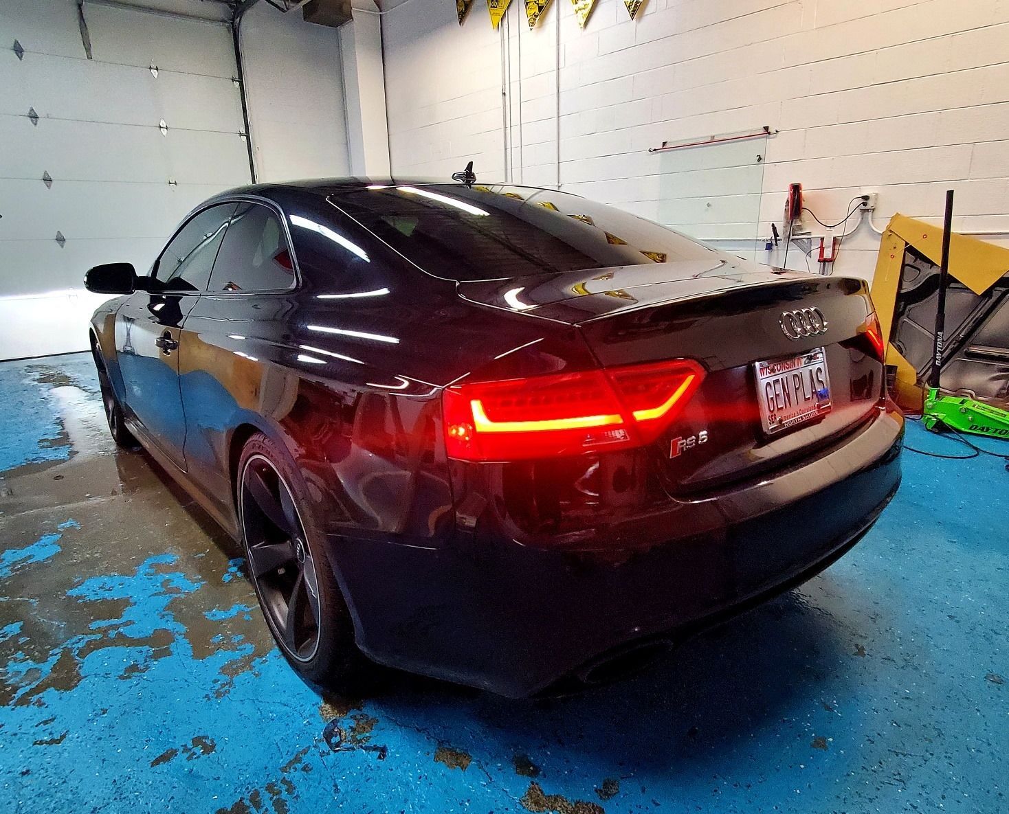 A black audi a5 is parked in a garage.