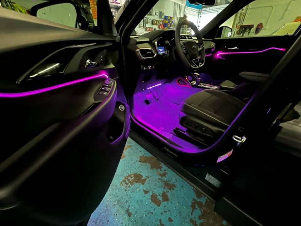 The inside of a car with purple lights on the dashboard.