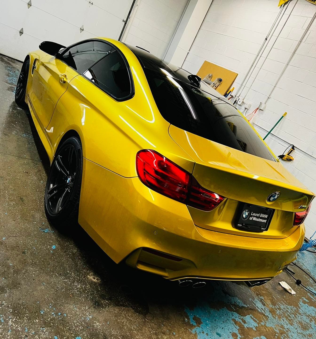 A yellow bmw is parked in a garage.