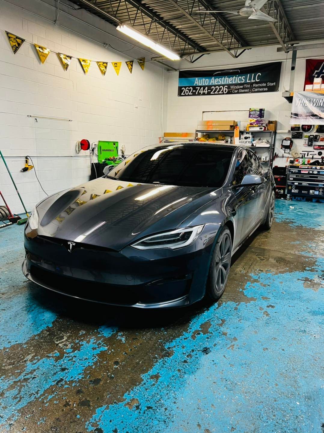 A tesla model s is parked in a garage.