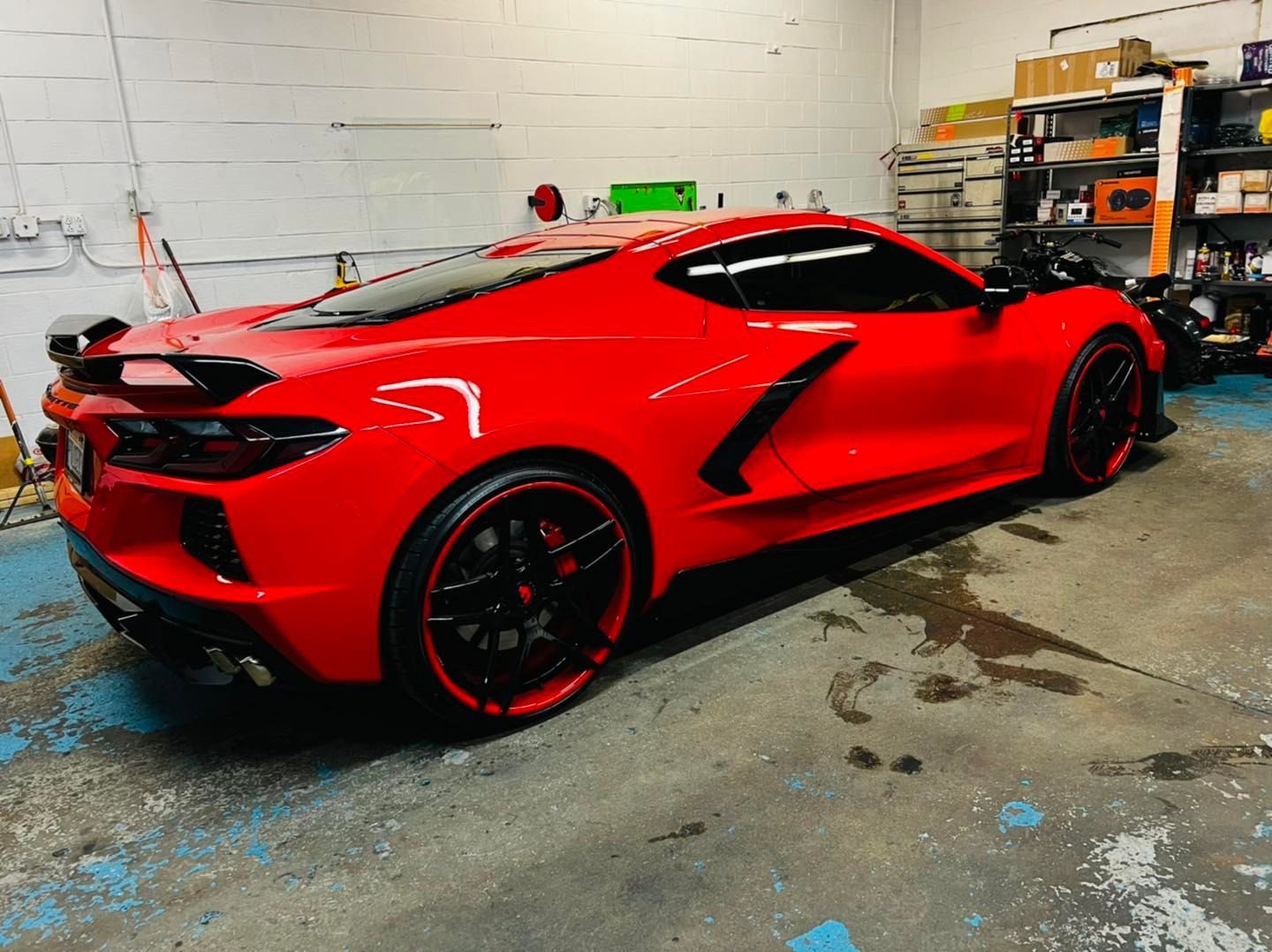 A red sports car is parked in a garage.