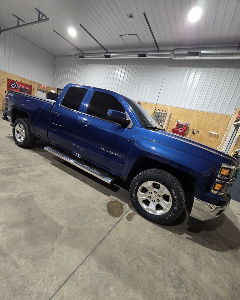 A blue truck is parked in a garage.
