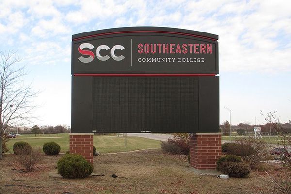 Sign for Southeastern Community College, dark gray with red and white logo over a black display.