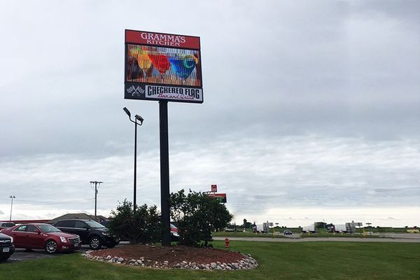 Billboard for Grandview Speedway with a colorful image and text against a cloudy sky.