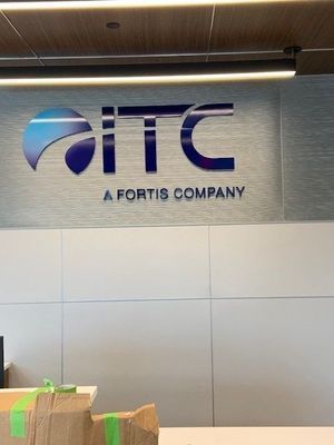 ITC logo: Blue and silver letters on a wall, 
