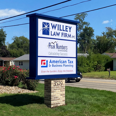 Sign for Willey Law Firm, Peak Numbers, and American Tax, on a brick and blue sign post, 3519 address.