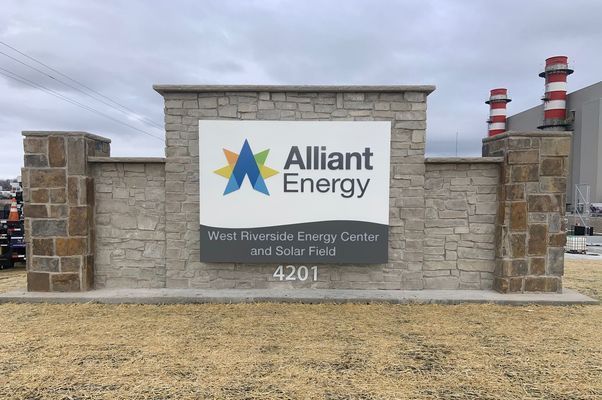 Sign for Alliant Energy's West Riverside Energy Center & Solar Field at 4201, with stone facade and company logo.