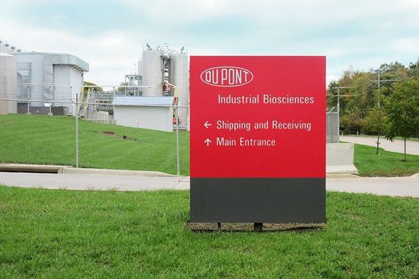 Red and gray sign for DuPont Industrial Biosciences with directions to shipping/receiving and main entrance.