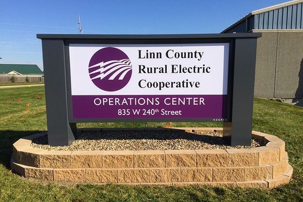 Sign for Linn County Rural Electric Cooperative Operations Center, purple and white on gray, with address 835 W 240th Street.