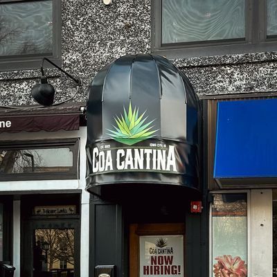 Coa Cantina restaurant entrance with black awning and agave logo. 