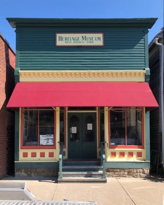 Heritage Museum, a two-story building with a red awning and green facade.