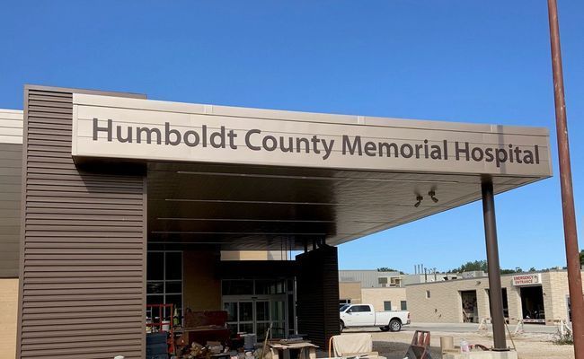 Humboldt County Memorial Hospital entrance sign. Brown and tan building with a blue sky.