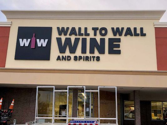 Wall to Wall Wine & Spirits store sign; black letters on tan background. 