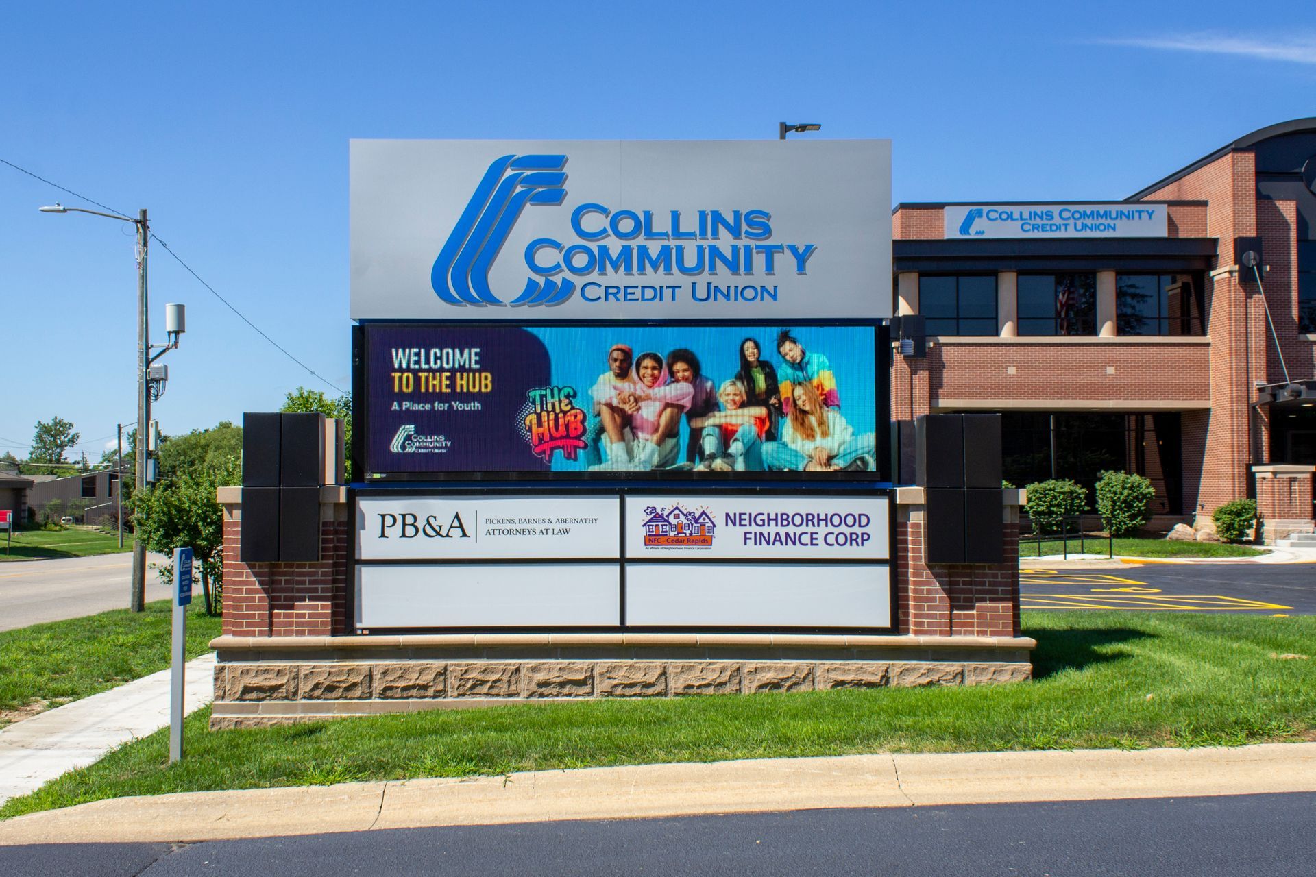 Sign for Collins Community Credit Union with digital display and brick facade.