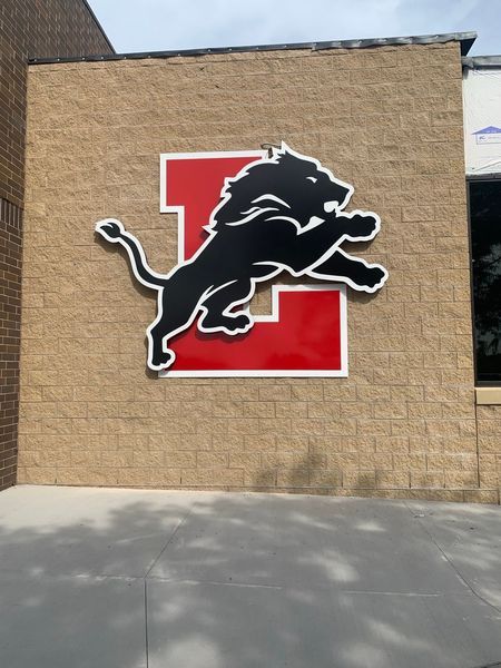 Lion mascot leaping over red 
