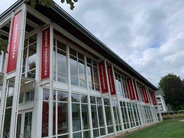 Modern building with red banners reading 