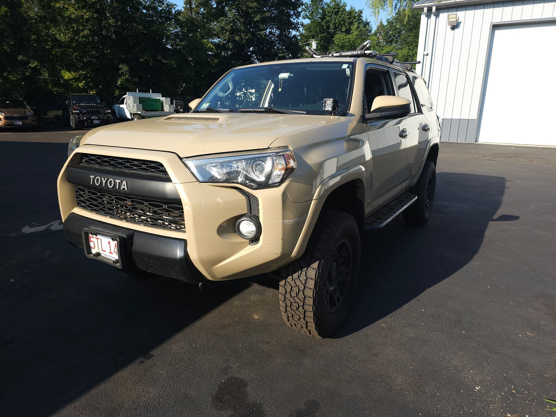 Beige Toyota SUV parked on a sunny lot, front-left view
