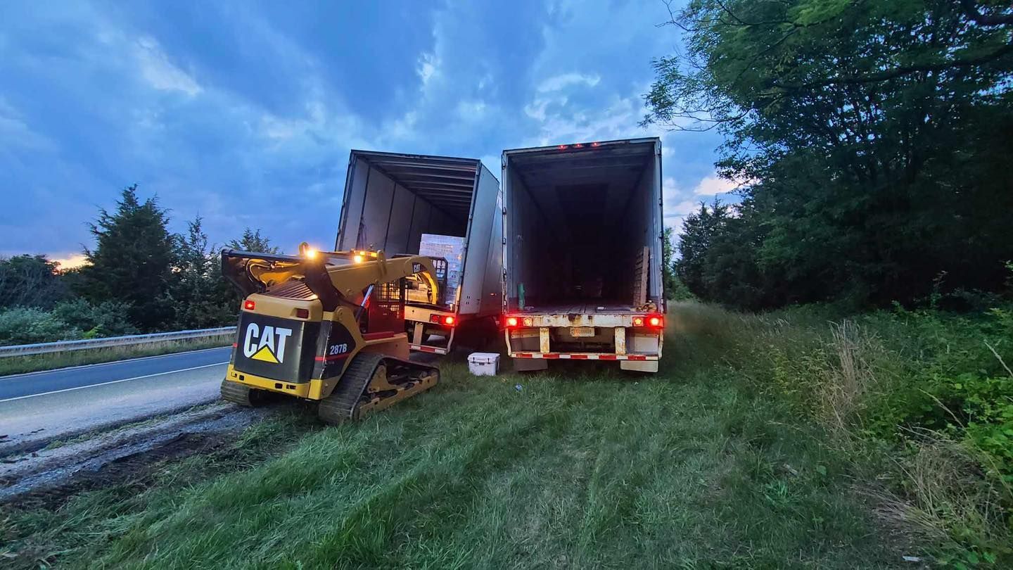 Two semi trucks are parked next to each other on the side of the road