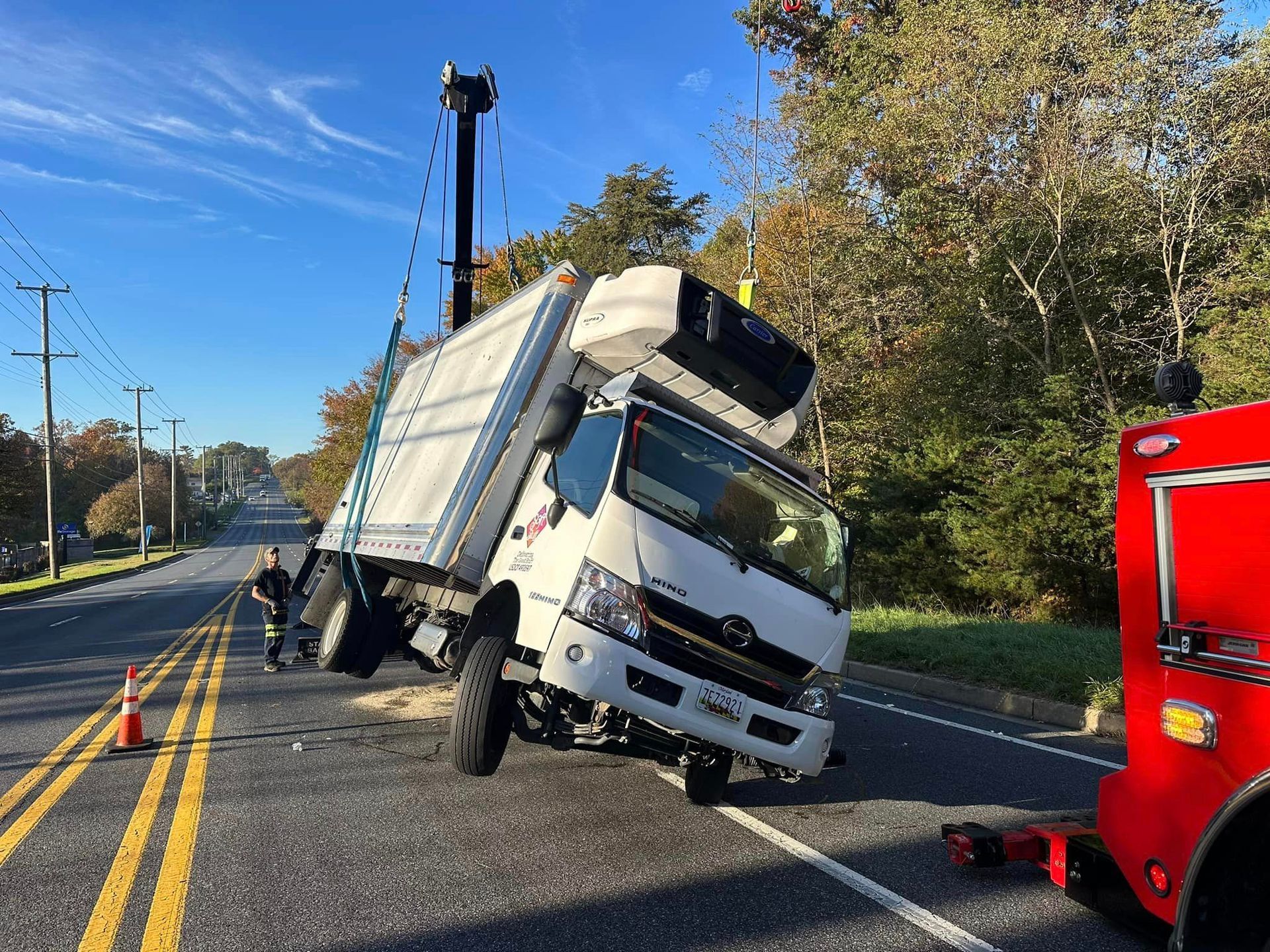 a garbage truck has crashed into a pole on the side of the road