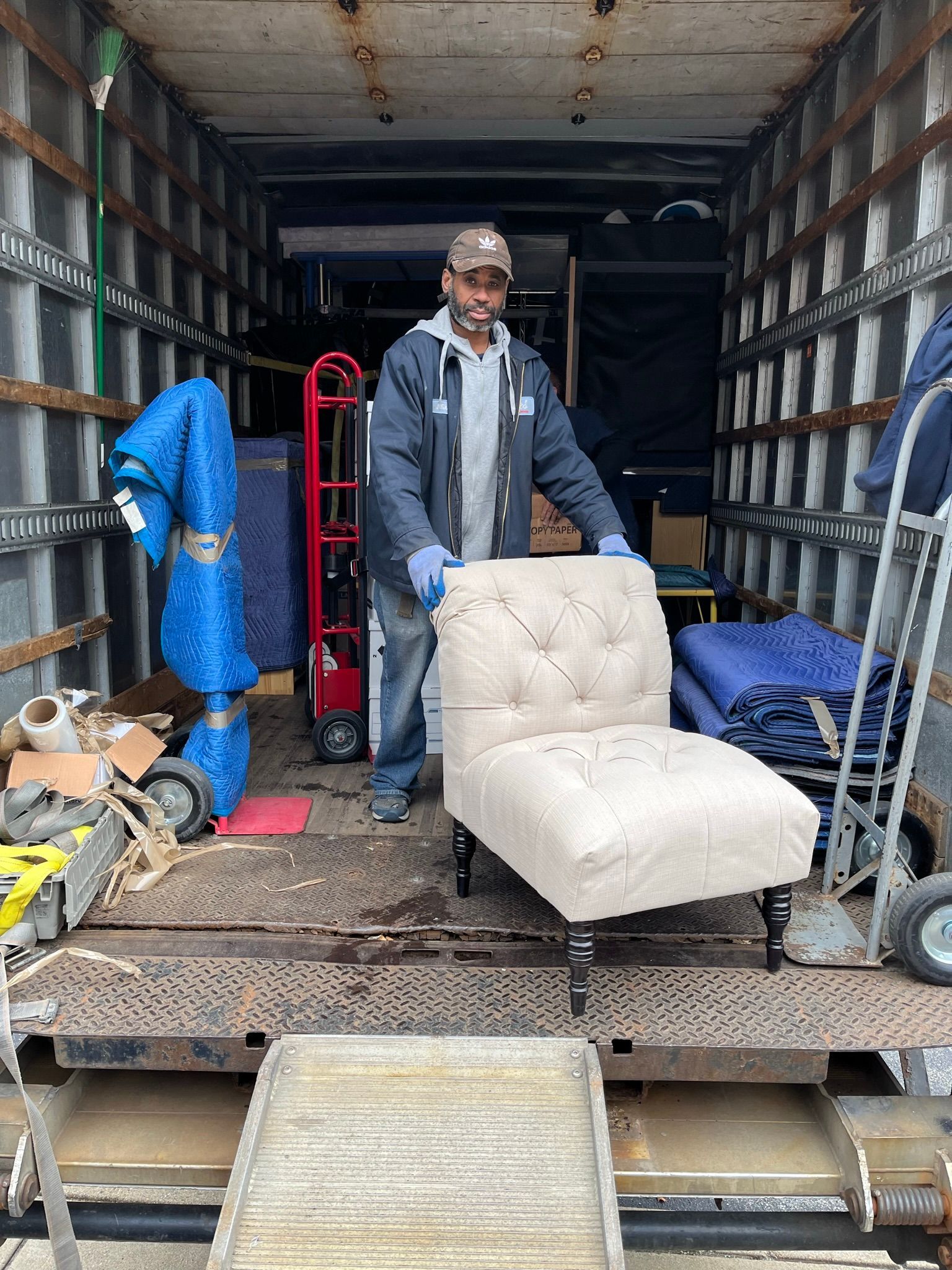 staff holding a white chair on a truck