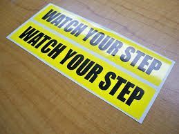 Two yellow caution stickers with the black text 