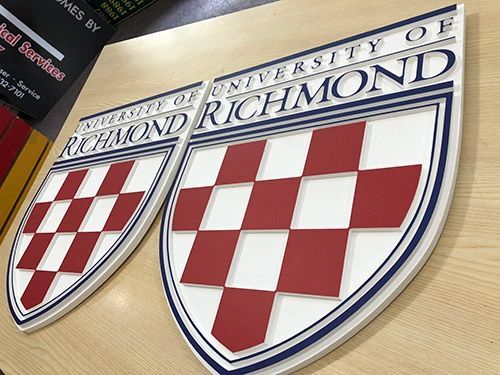 Two 3D, shield-shaped signs featuring the University of Richmond logo with a red and white checkerboard pattern.