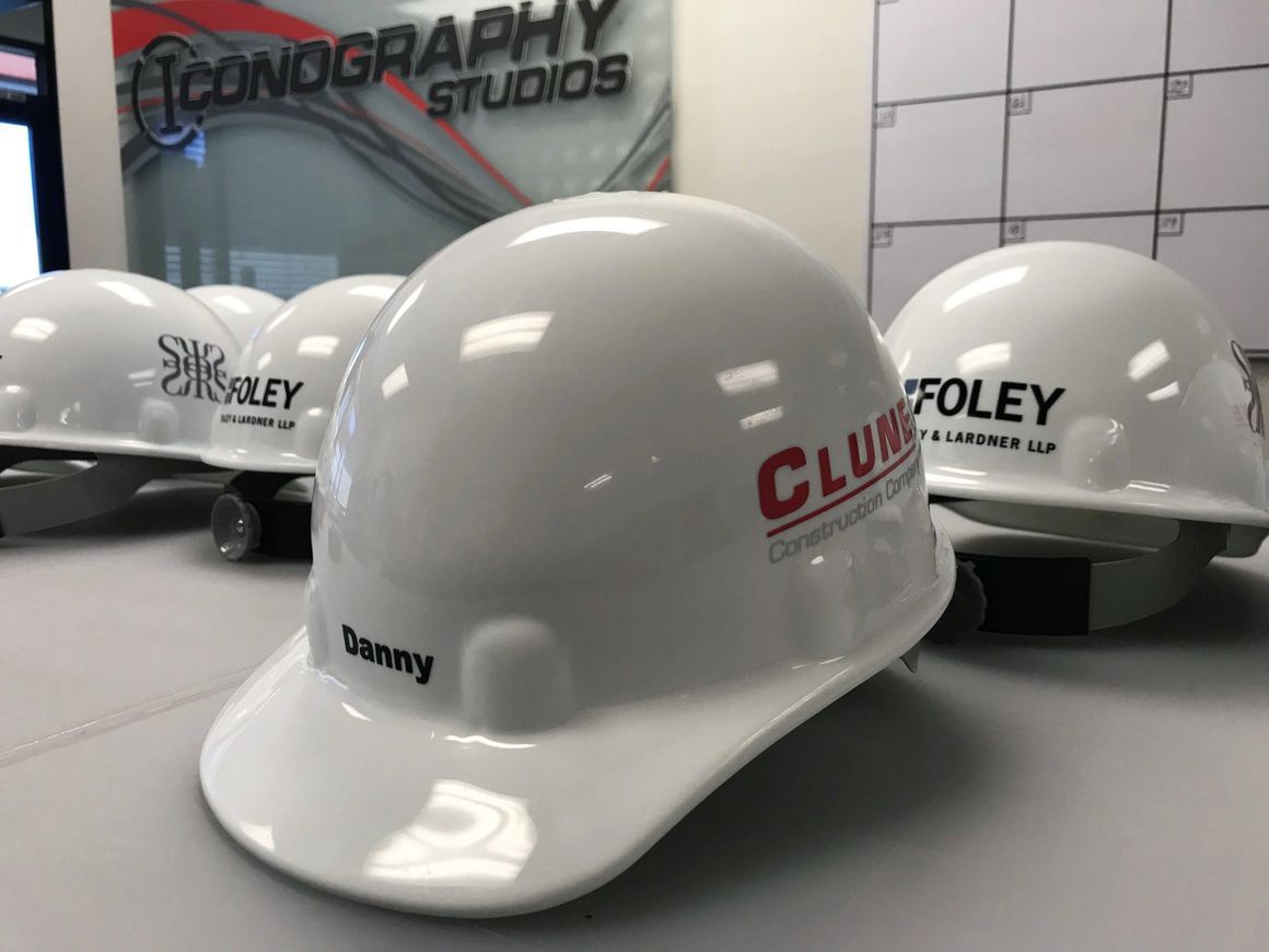 Several white hard hats, including one labeled 
