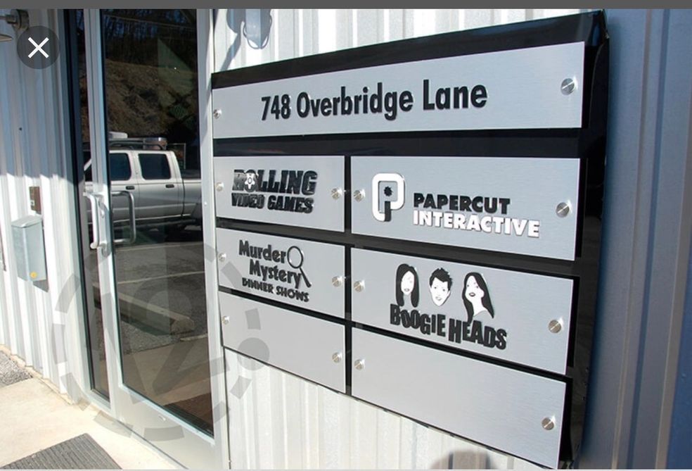 A multi-tenant sign at 748 Overbridge Lane listing Rolling Games, Papercut Interactive, Murder Mystery, and Boogie Heads.