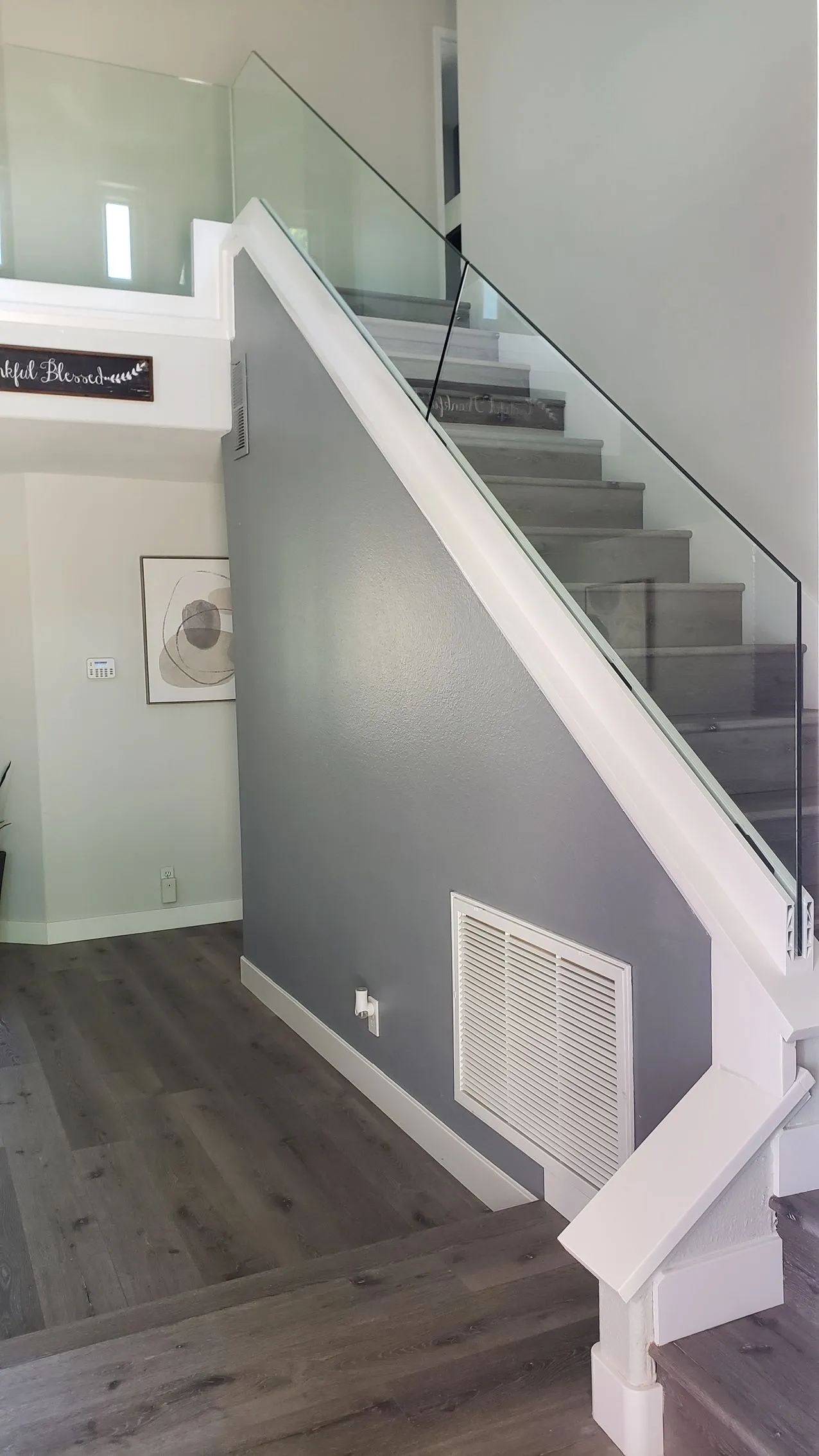 Modern interior staircase with gray steps, white railing, and frosted glass side panels in a hallway