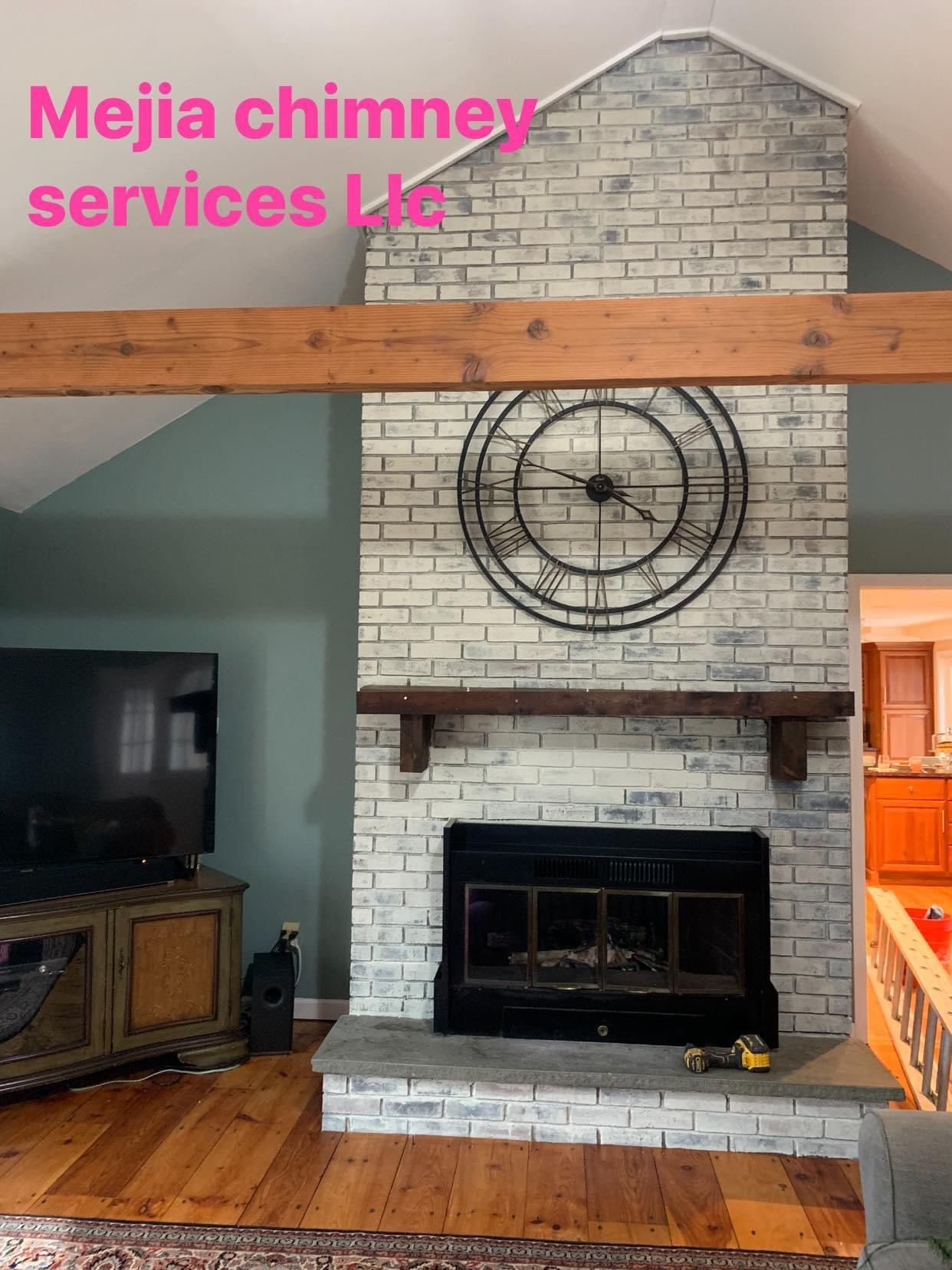 A whitewashed brick fireplace with a large metal wall clock, dark wood mantel, and gray stone hearth in a living room.