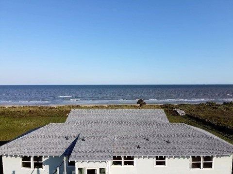 White house roof by the ocean under a clear blue sky