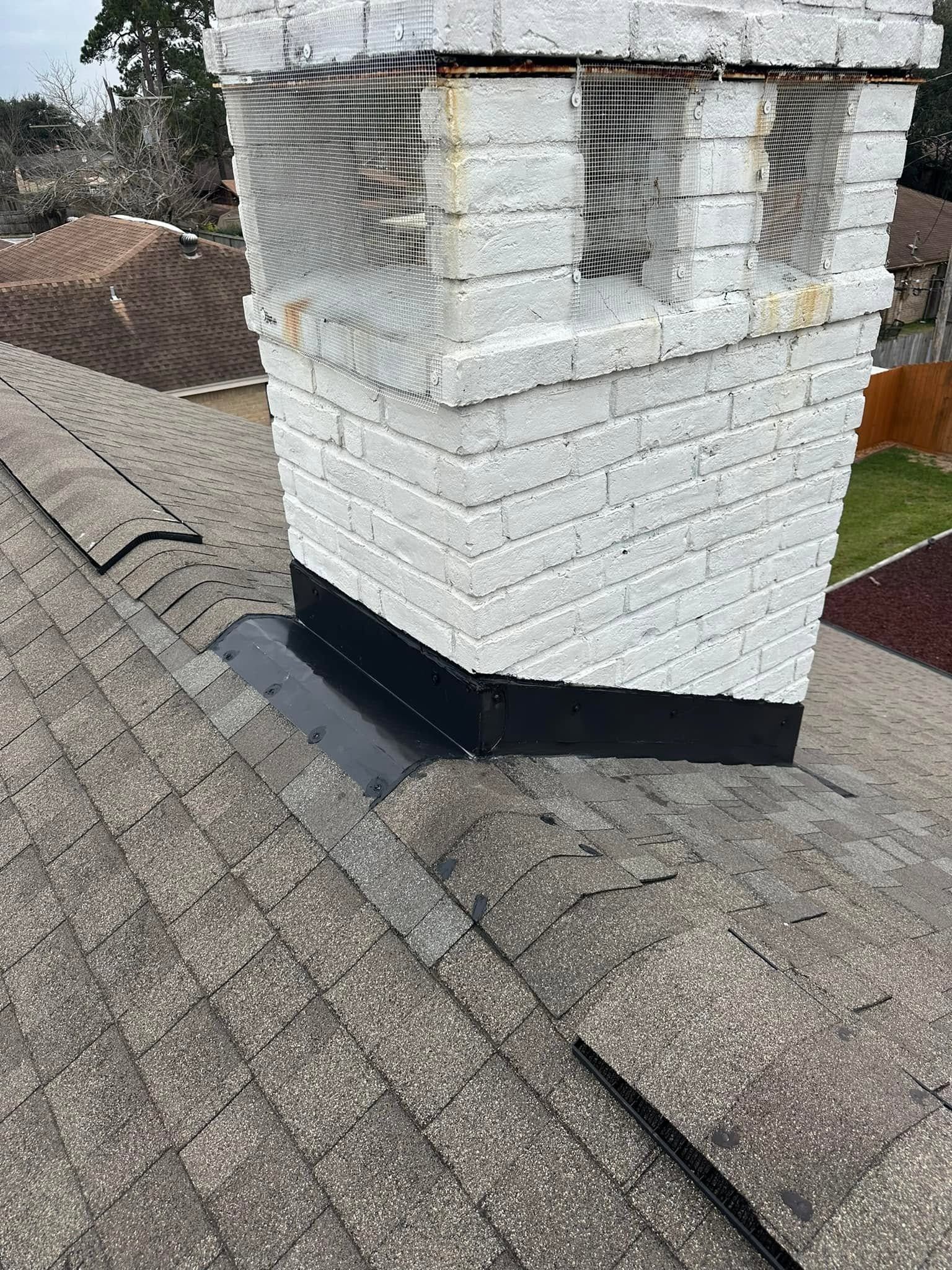 White brick chimney on a shingled roof, wrapped with protective netting at the top.