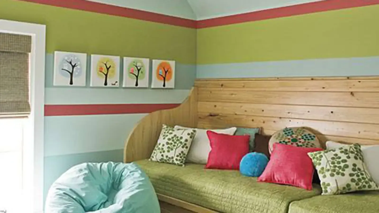 A colorful bedroom with striped walls, wooden headboard, and various pillows.
