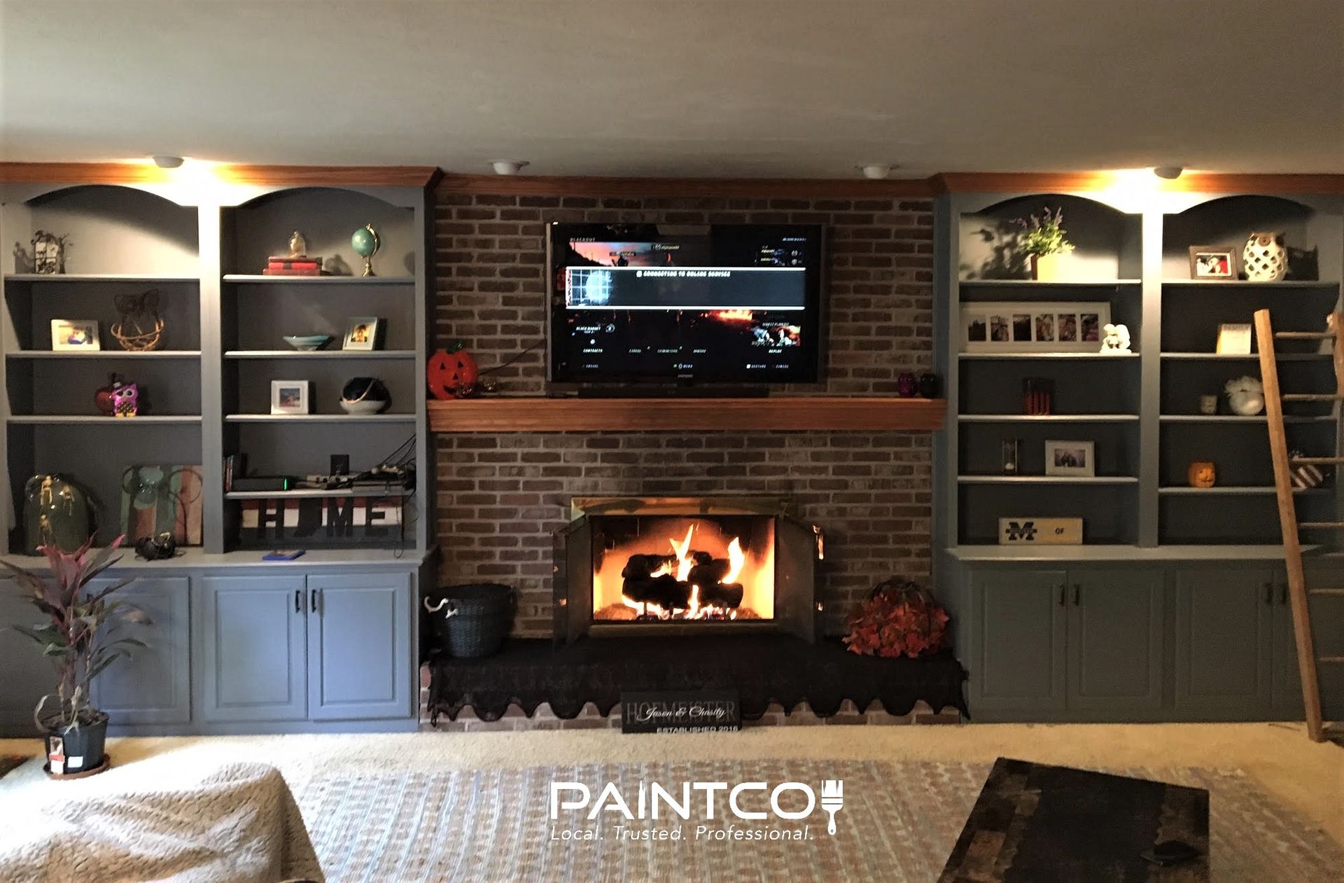 Fireplace with bookshelves flanking it, TV above, all in a living room setting.