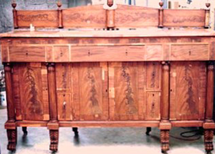 Antique wooden sideboard with ornate carving and multiple drawers and doors.